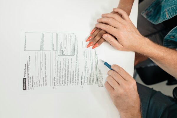 A couple fills out an adoption request form, highlighting commitment and future family planning.